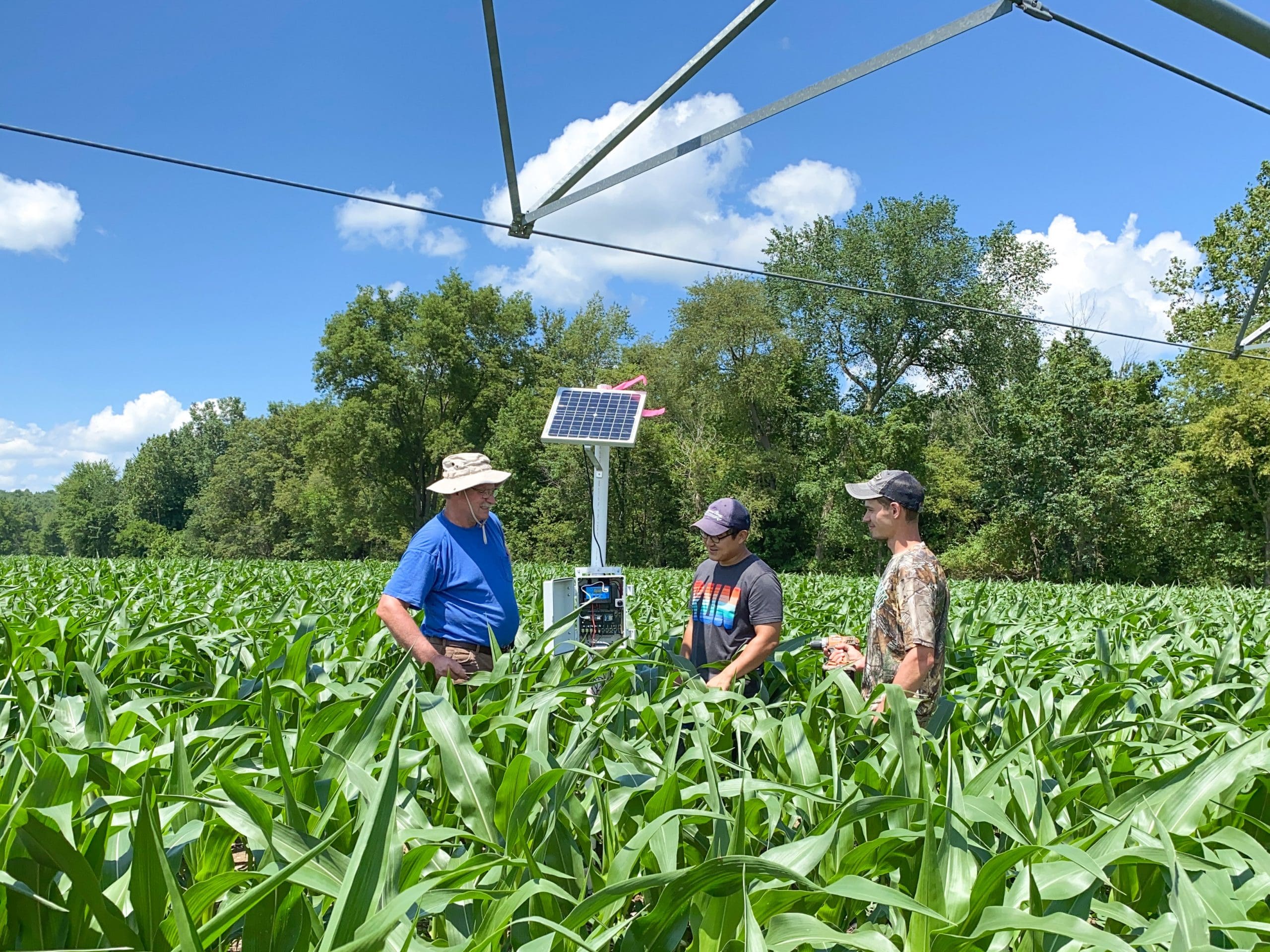Younsuk Dong, a specialist in MSU’s Department of Biosystems & Agricultural Engineering, works with Lyndon Kelley, irrigation extension educator, and Brenden Kelley, a student research assistant, to install LOCOMOS stations in a corn field in Tekonsha, Michigan.